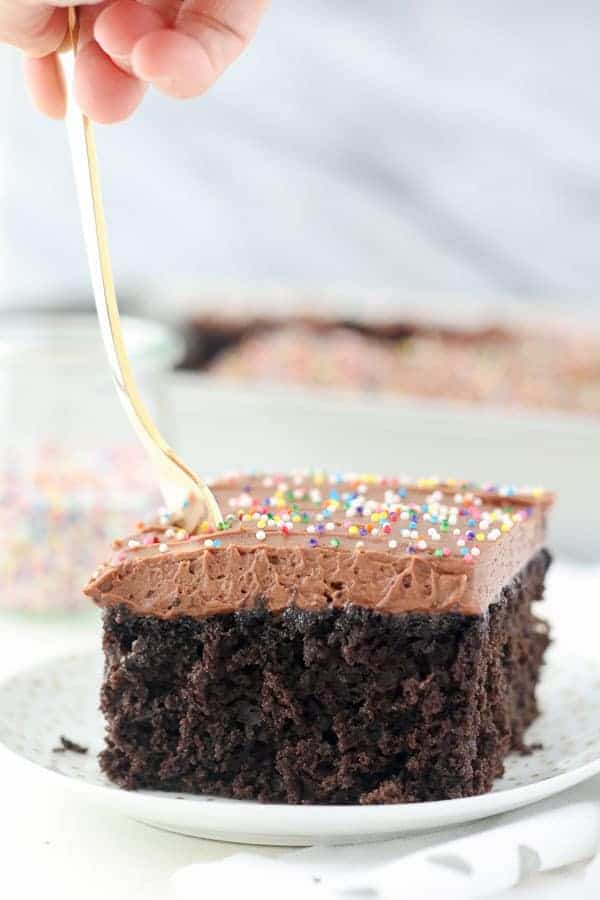 en gaffel synker ned i en skive fugtig chokoladekage
