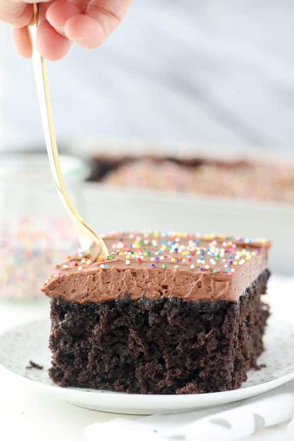 Un tenedor que se hunde en una rebanada de pastel de chocolate húmedo