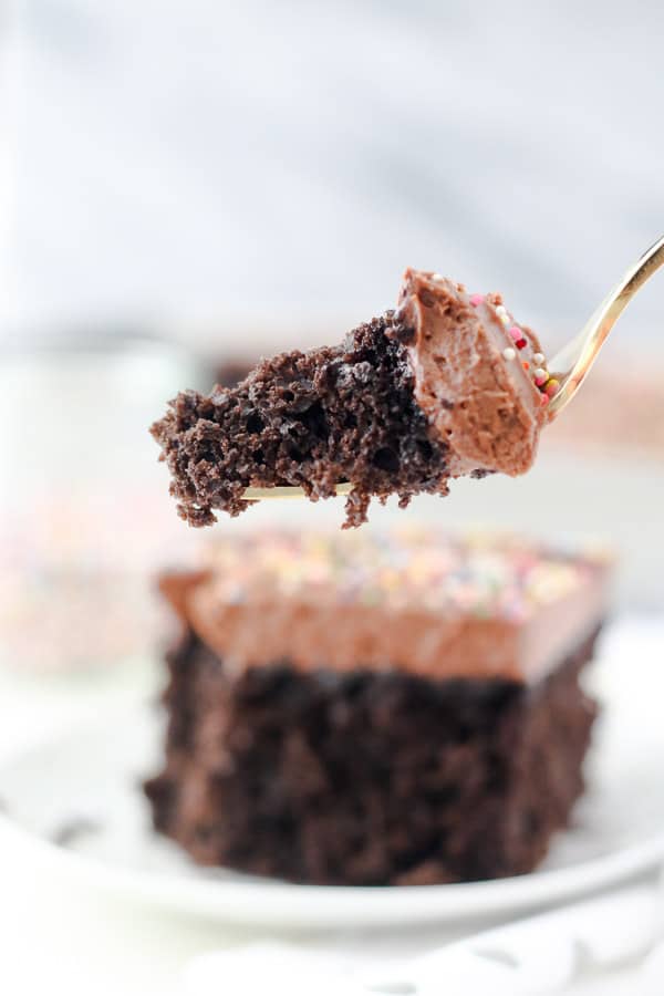 Une fourchette en or avec une bouchée géante de gâteau au chocolat dessus.