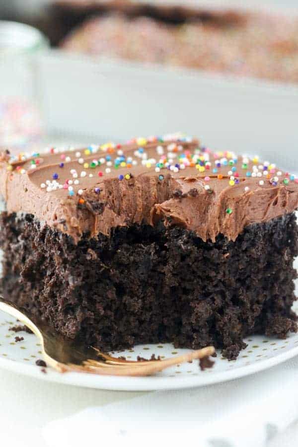 Un primo piano di una fetta mezza mangiato di torta al cioccolato fondente con una glassa di cioccolato e spruzza.