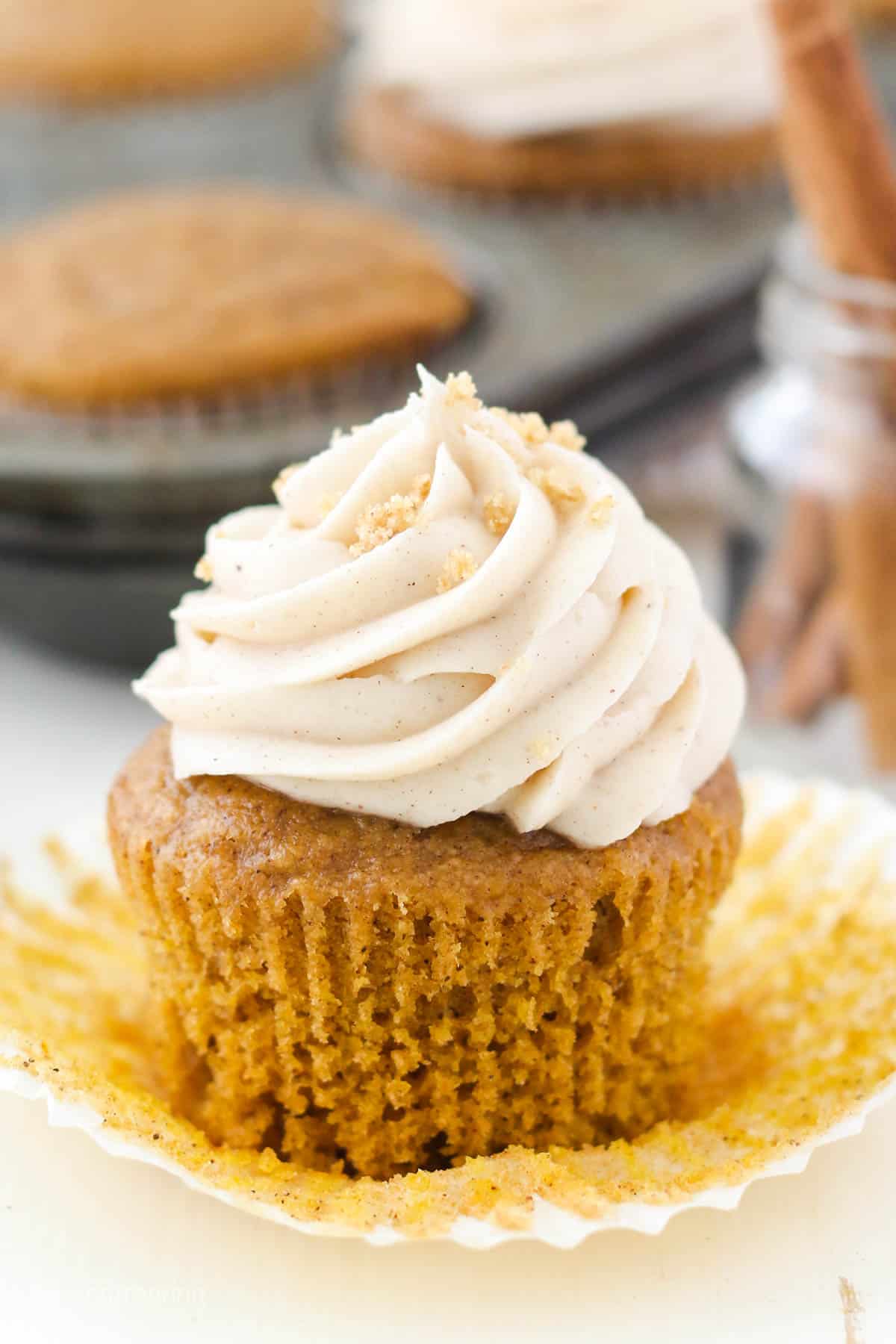 Pumpkin cupcake with cream cheese frosting with the wrapper pulled off