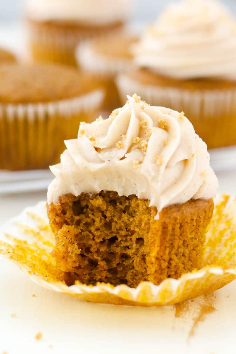 A pumpkin cupcake with a bite missing