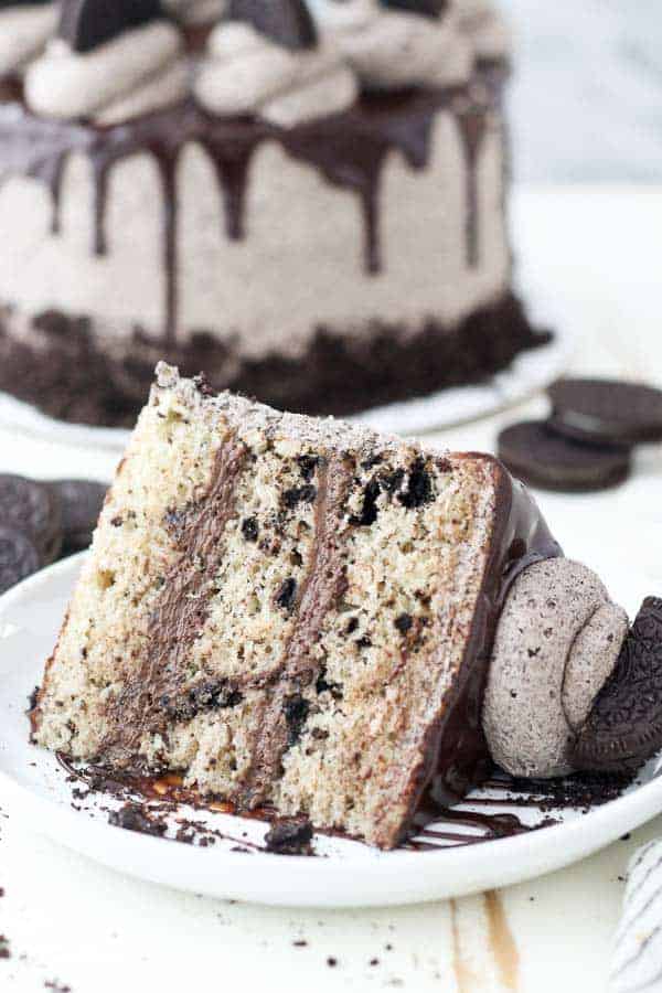 A giant slice of Oreo Cookies and Cream Cake on a white rimmed plate