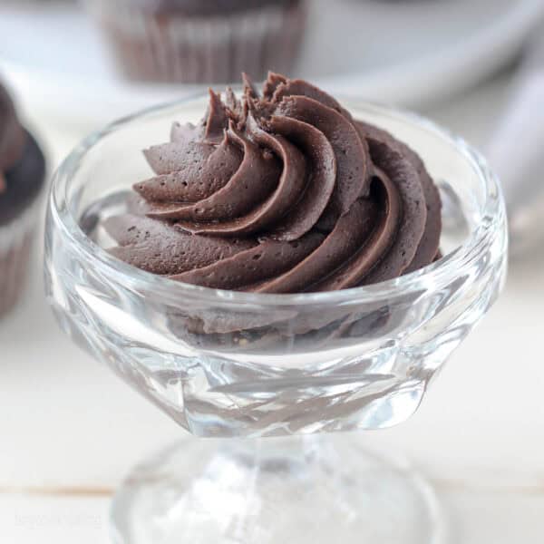A swirl of chocolate cream cheese frosting in a glass bowl.