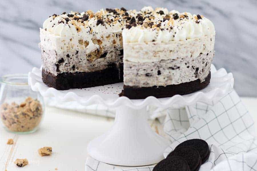 A large white cake stand with an oreo cheesecake dessert on top