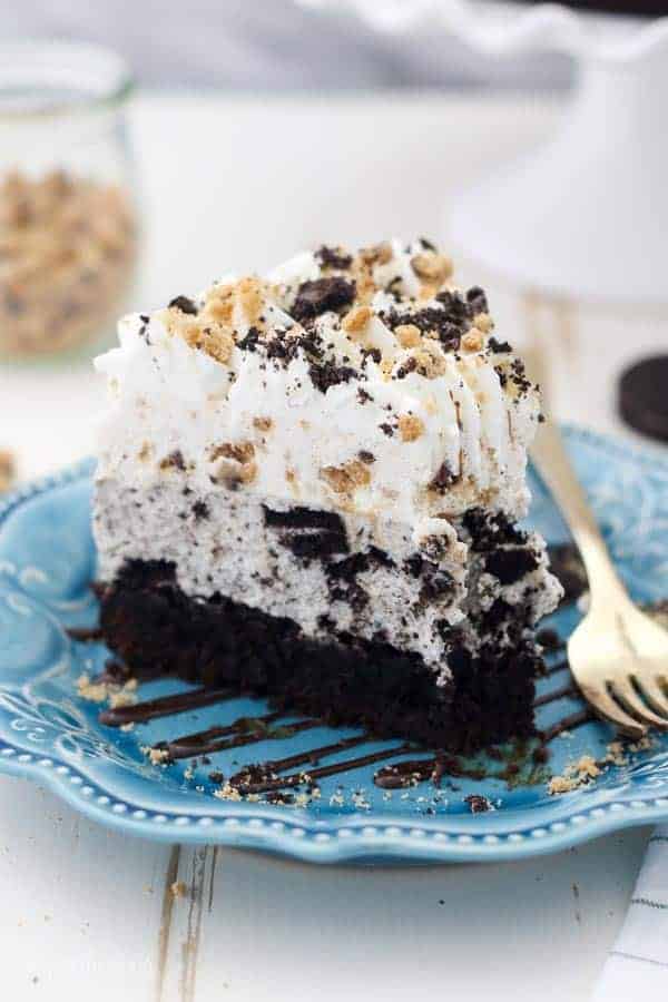 Image of a triple layer Oreo mousse cake with a brownie on the bottom. 