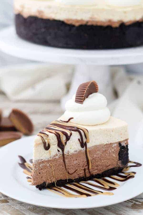 A large slice of peanut butter chocolate mousse pie with hot fudge and melted peanut butter dripping down the sides. There's a big dollop of whipped cream on top and a half a Reese's Peanut Butter Cup.