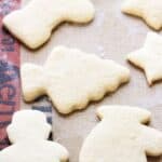 A baking tray lined with a silicone baking mat, with baked sugar cookies on it.