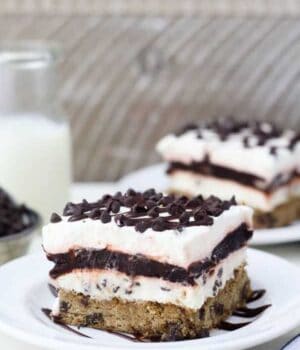 A slice of layered chocolate chip cookie lush covered in hot fudge sauce and chocolate chips