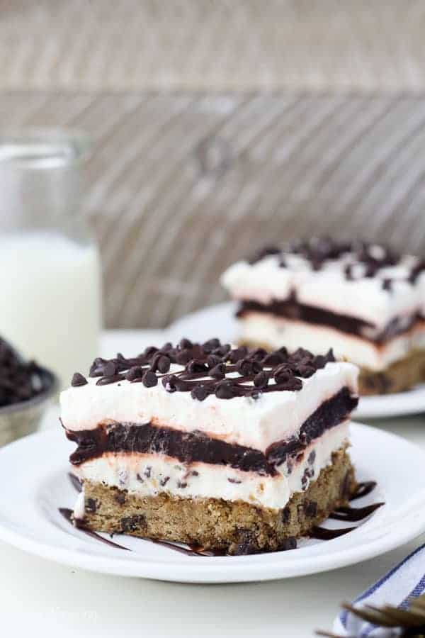 A slice of layered chocolate chip cookie lush covered in hot fudge sauce and chocolate chips