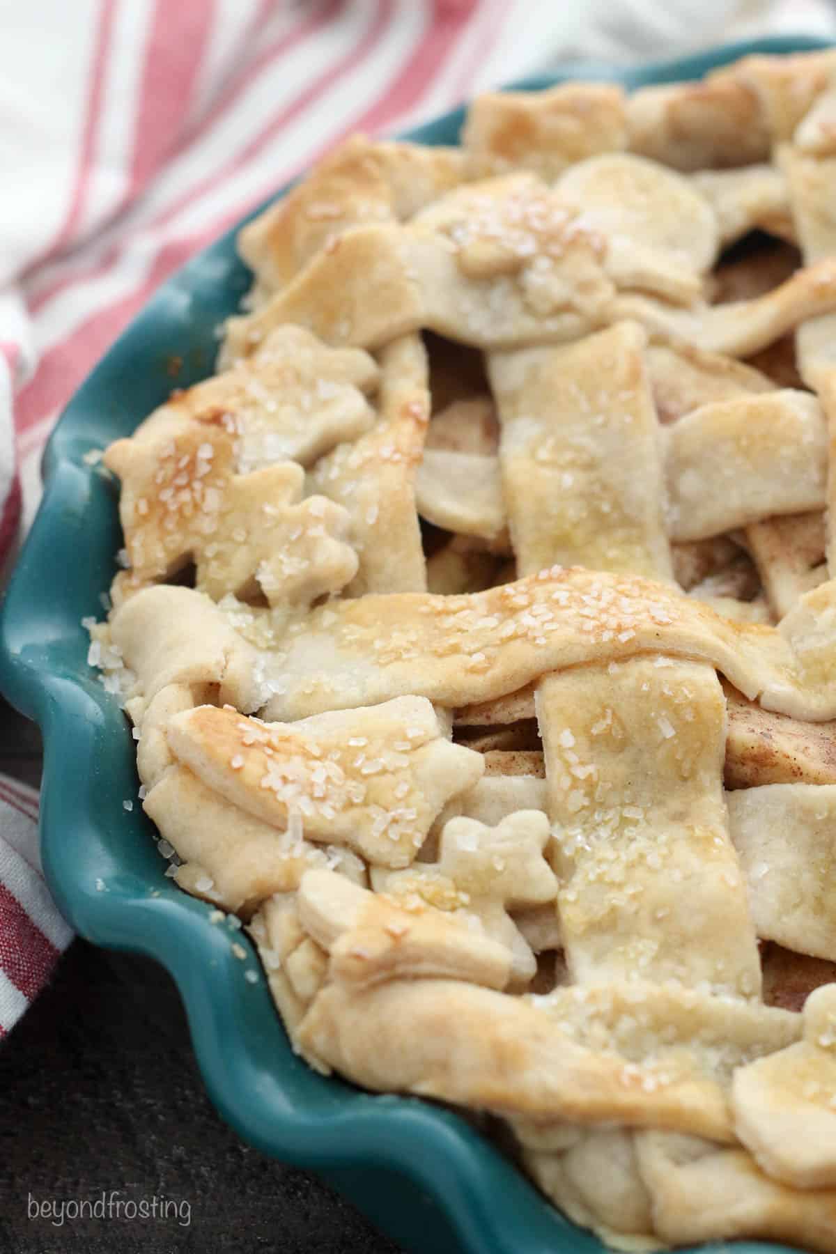 A close-up shot of a lattice crust with cut outs of leaves and acorns on top