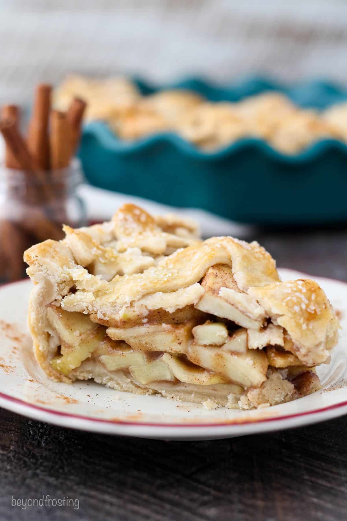 A side view of a slice of apple pie showing the lattice crust and the apple pie filling