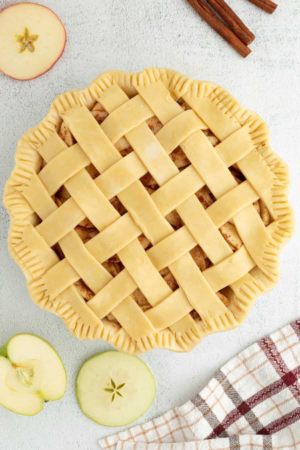 Unbaked apple pie topped with a lattice crust.