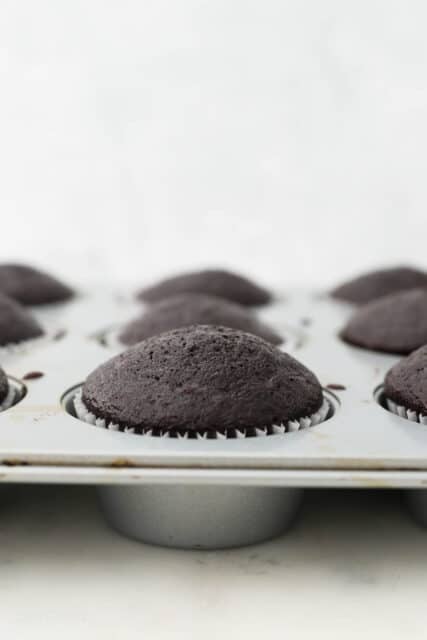 Baked chocolate cupcakes in a cupcake pan.