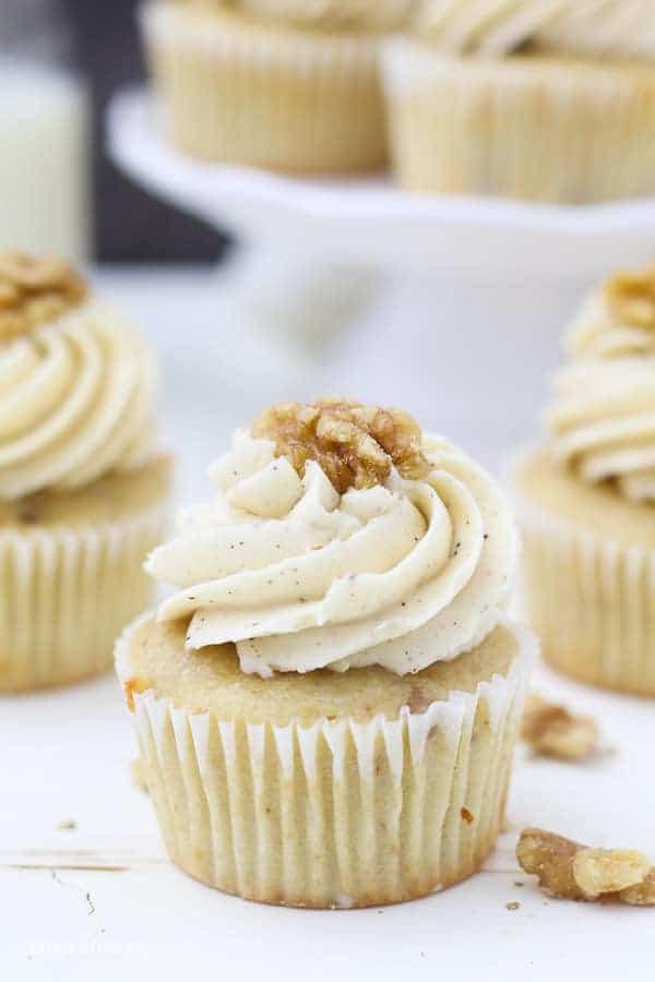 A perfect maple walnut cupcake with a big swirl of browned butter frosting and a walnut on top