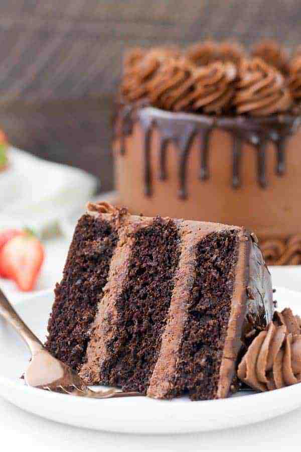 A big slice of chocolate cake with layered of chocolate frosting and finished with a chocolate ganache. 