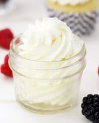 A piped swirl of mascarpone whipped cream in a glass jar.