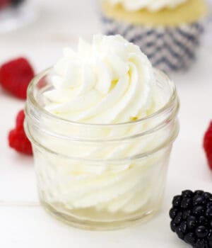 A piped swirl of mascarpone whipped cream in a glass jar.