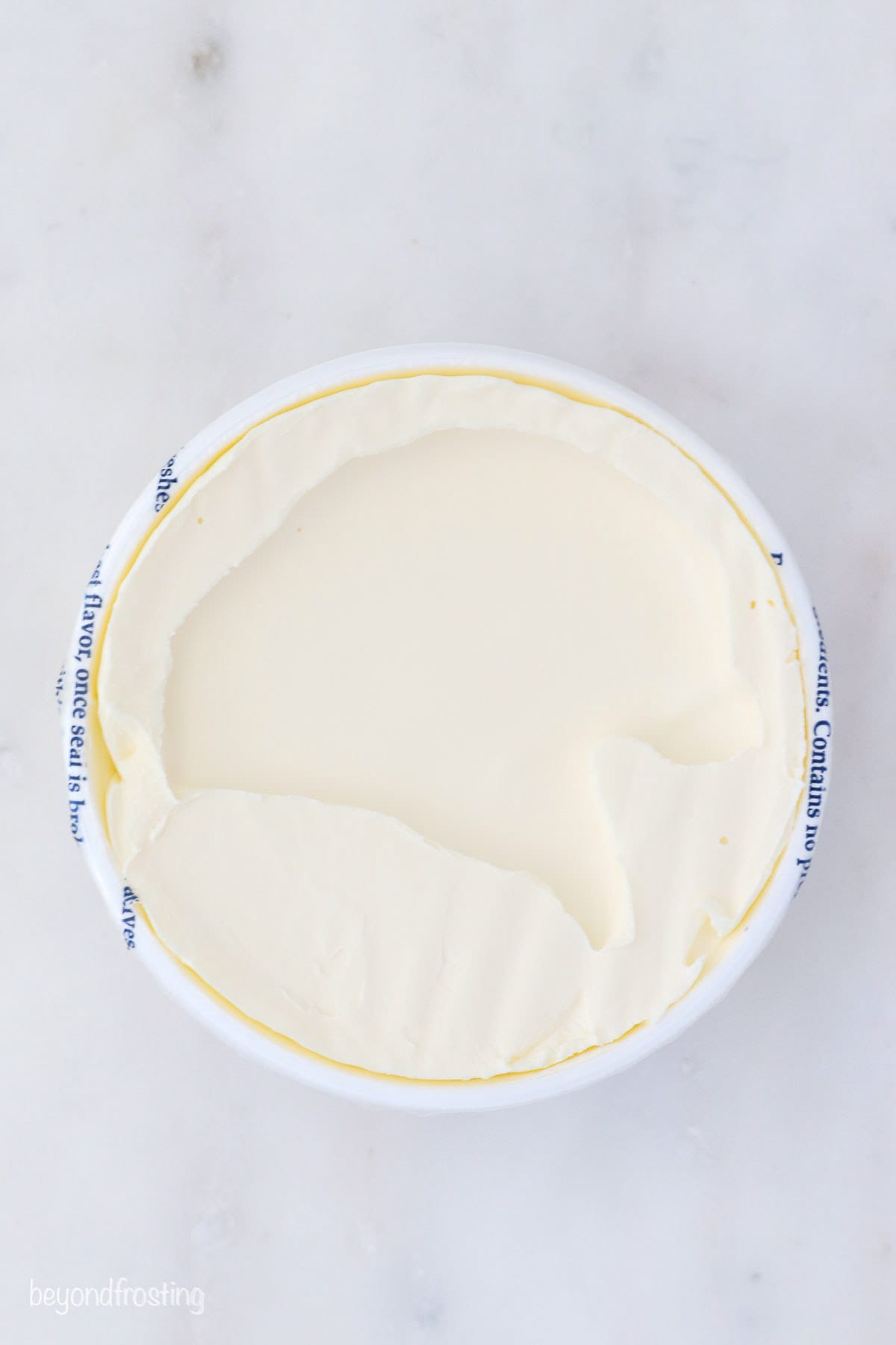 Overhead view of a container of mascarpone cheese.