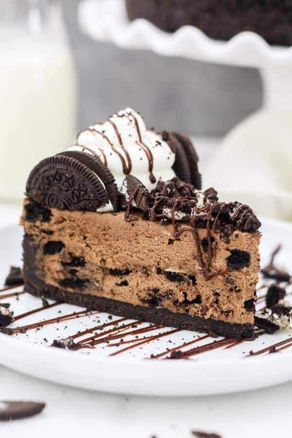 A mouthwatering slice of chocolate cheesecake is loaded with Oreos, its got chocolate sauce dripping down the sides and more crushed Oreos on top