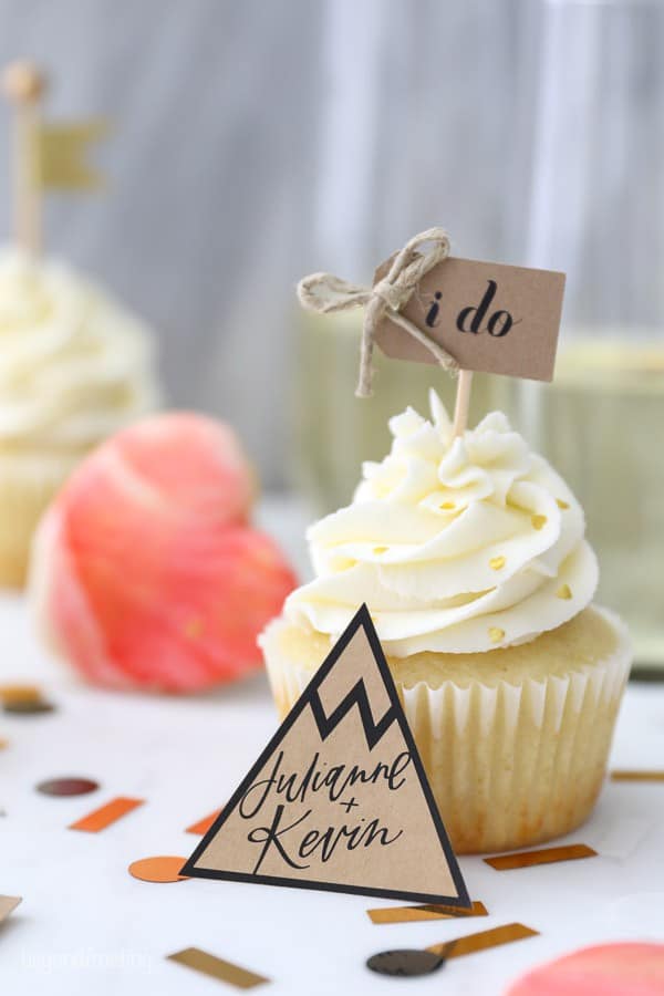 These engagement themed cupcakes are super cute decorated with buttercream and a little "I Do" cupcake topped. Leaning up against the cupcake is a mountain shaped cutout that says "Julianne + Kevin"