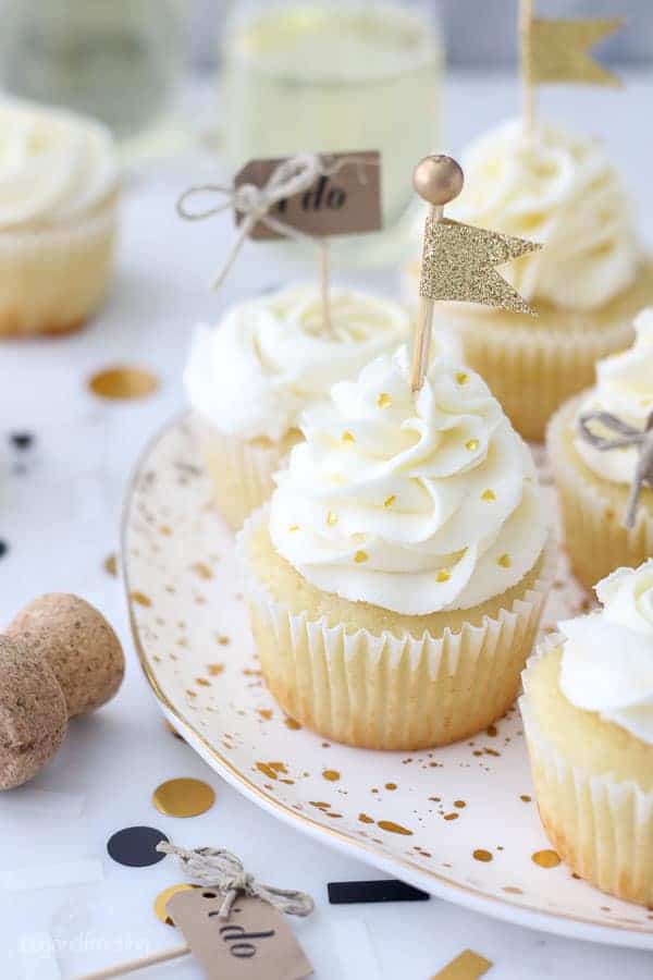 These engagement themed cupcakes are super cute decorated with a beautiful buttercream swirl with gold heart shaped sprinkles a a gold flag cupcake topped