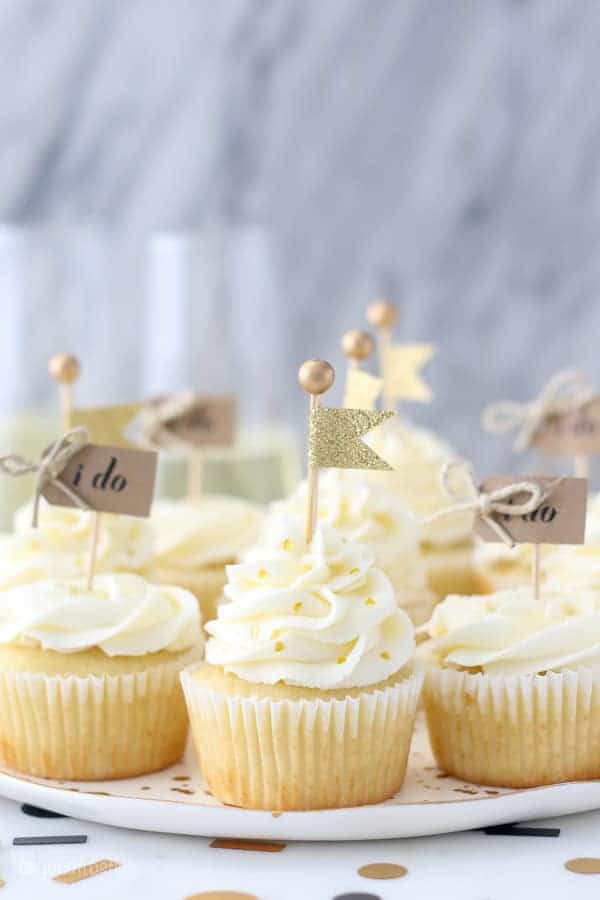 These engagement themed cupcakes are super cute decorated with a buttercream rose and a little gold flag cupcake topper