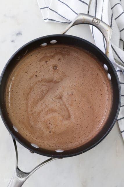 Cooking dry ingredients with milk in a pot.