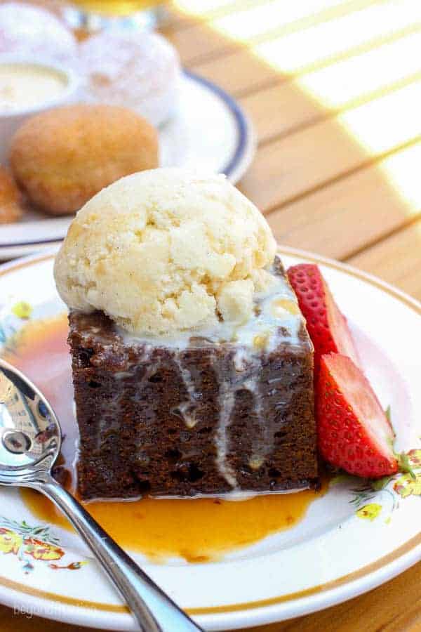 Chocolate brownie with a scoop of ice cream and two strawberries