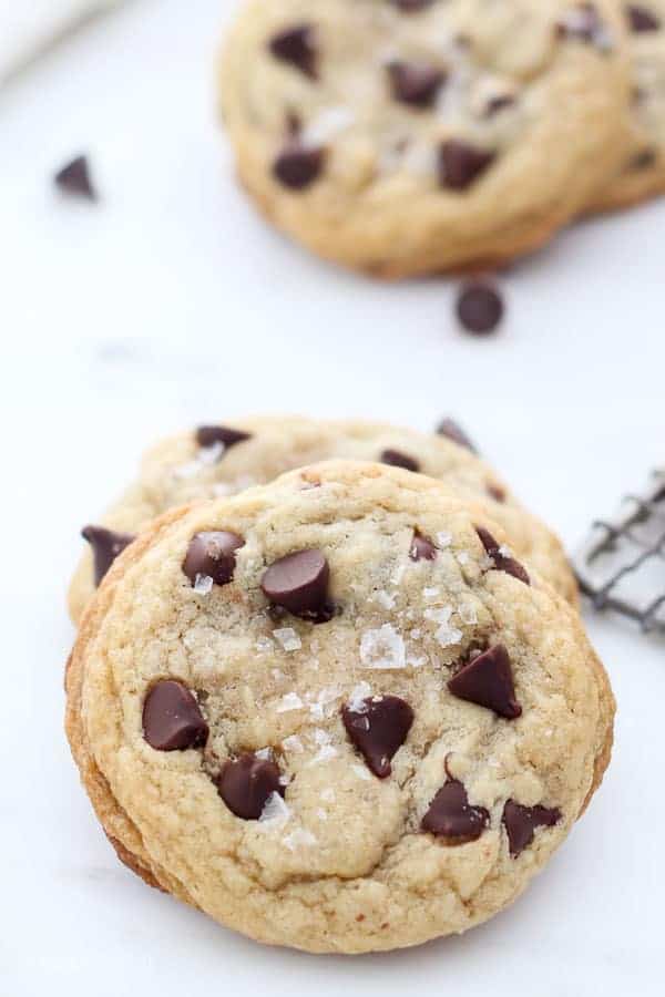 A chocolate chip cookie leaning up against another cookie