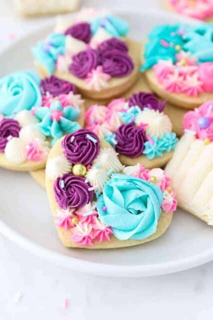 A gorgeous plate of sugar cookies decorated with vanilla buttercream