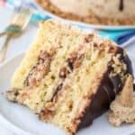A close up shot of a slice of Drumstick Cake that has layers of cake, chocolate fudge and peanuts