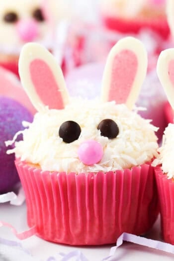 Assorted Easter bunny cupcakes in pink liners decorated with chocolate ears.