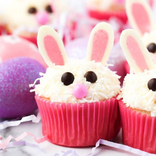 Assorted Easter bunny cupcakes in pink liners decorated with chocolate ears.