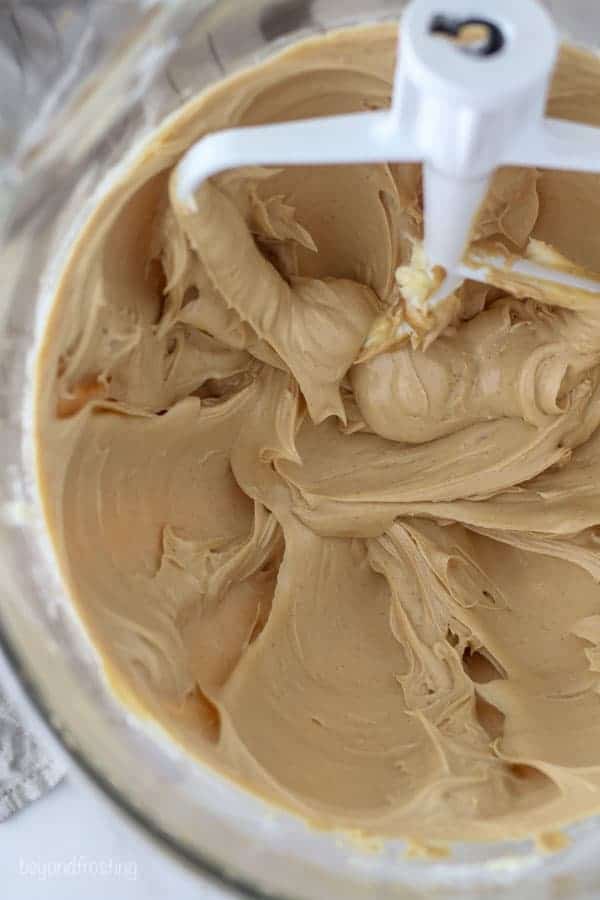A photo of the inside of a glass mixing bowl showing the creamed butter and peanut butter