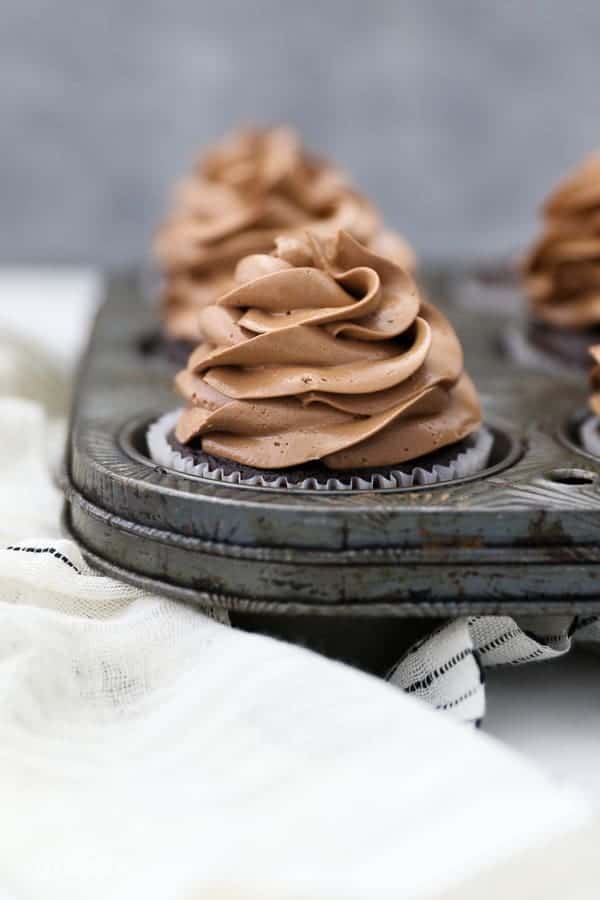 A straight on shot of 6 cupcakes sitting in a vintage cupcake pan