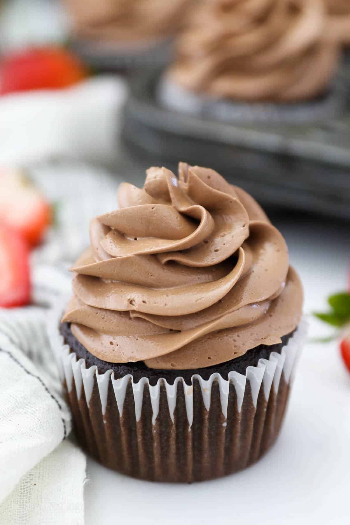 One chocolate cupcake frosted with chocolate Swiss meringue buttercream