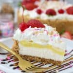 A gorgeous slice of a no-bake banana split pie to show all the layers including cheesecake, banana pudding, whipped cream and lots of sundae toppings