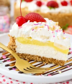 A slice of banana split pie topped with whipped cream, maraschino cherries, and sprinkles on a plate.