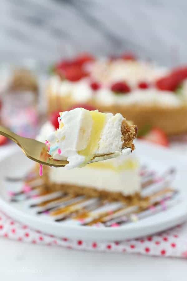A gold fork with a big slice of banana split pie on it showing all the layers