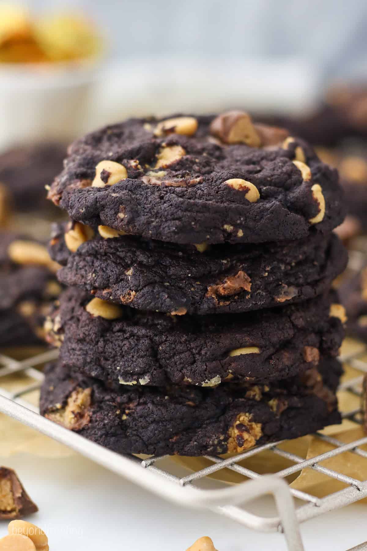 A stack of chocolate peanut butter cookies on a white wire rack.