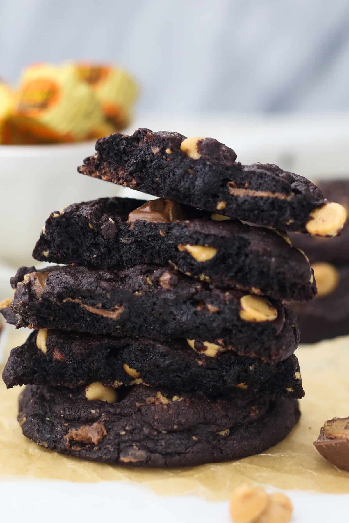 A stack of chocolate peanut butter cookie halves on a countertop.