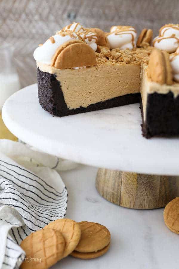 A look inside this no-bake peanut butter pie showing the fluffy filling. It has an Oreo crust and it's sitting on a marble cake stand