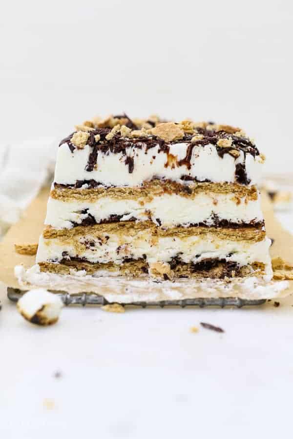 A head on shot of a layered s'mores ice cream cake, there's 3 layers of graham cracker and 3 layers of ice cream with lots of chocolate.