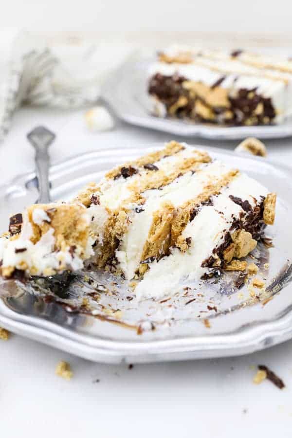 A slice of s'more ice cream cake on a silver vintage plate and a silver fork