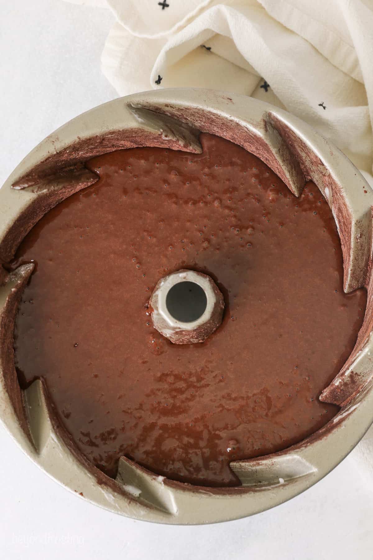 Overhead view of chocolate cake batter in a bundt pan.