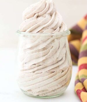 A mason jar piped full of cinnamon whipped cream with a gorgeous swirl.