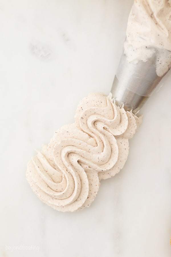 An overhead shot of a swirl of whipped cream coming out of piping bag.