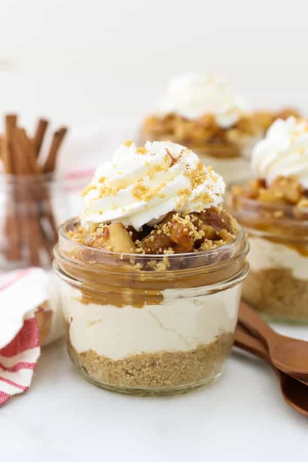A mini cheesecake in a glass mason jar with lots of homemade whipped cream on top