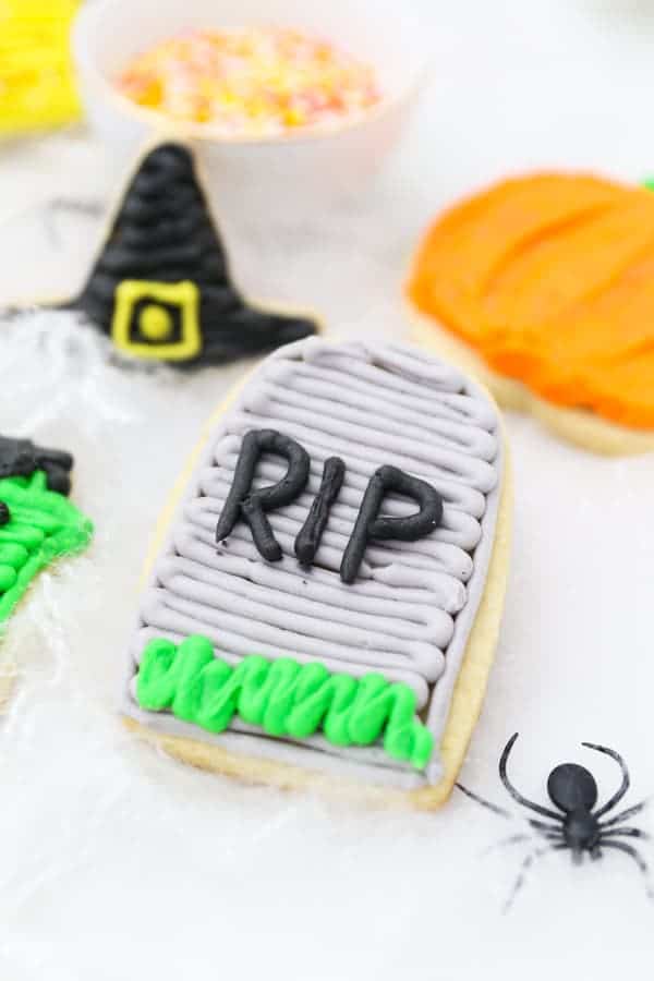 An RIP tombstone sugar cookie laying in fake spider webs